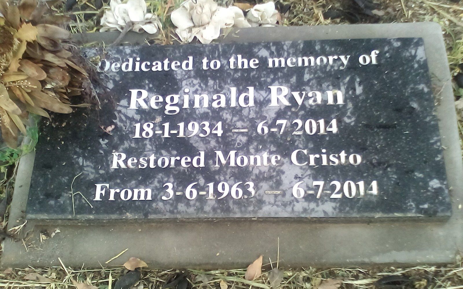Memorial plaque for Reginald Ryan, who restored Monte Cristo, with faded flowers beside it